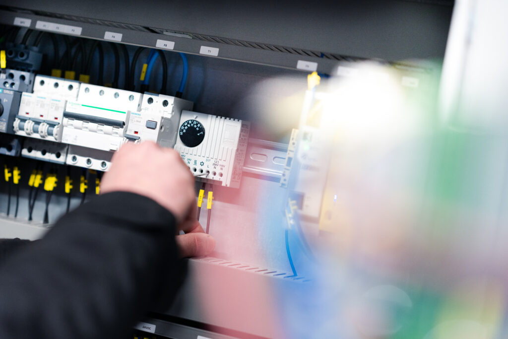 Tekniker från VUAB arbetar vid elcentral i bioenergianläggning.